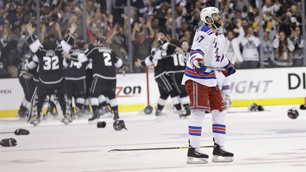 ZKLAMN A JSOT.  Benoit Pouliot z New York Rangers polyk hokost, za nm se raduj hokejist Los Angeles. 