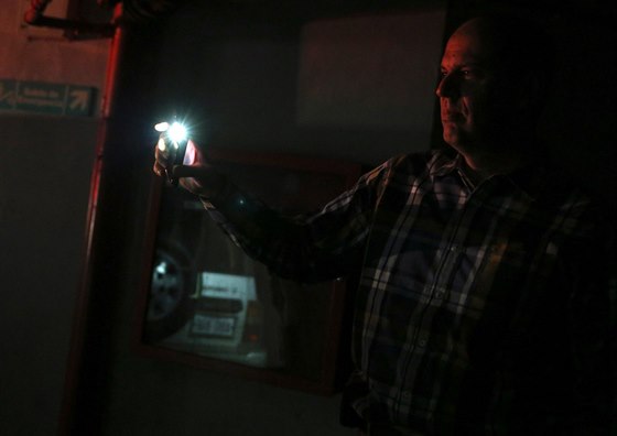 Mu si svítí telefonem, aby nael své auto bhem výpadku proudu v Caracasu (27....