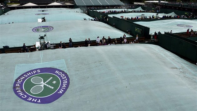 PLACHTY. Ve Wimbledonu pi deti tradin zatahuj nad travnatmi kurty zelen plachty s logem tenisovho turnaje.