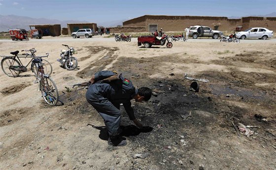 Afghánský policista prohlíí místo sebevraedného útoku, kde zahynuli tyi...