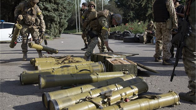 Ukrajint vojci shromauj zbran, kter ve Slavjansku nechali ustupujc rebelov. (5. ervence 2014)
