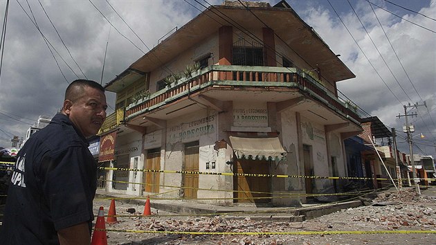 Mexick policista hldkuje ped domem ve mst Huixtla, kter citeln pokodilo pondln zemtesen.