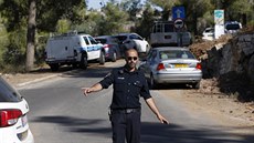 Izraelský policista odklání dopravu od místa, kde bylo nalezeno tělo... Izraelský policista odklání dopravu od místa, kde bylo nalezeno tělo...