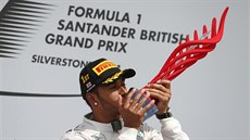 Lewis Hamilton se tulí k trofeji pro vítze Velké ceny Británie.