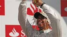 TSTÍ. Britský pilot Lewis Hamilton se polévá umivým vínem po vítzství ve...