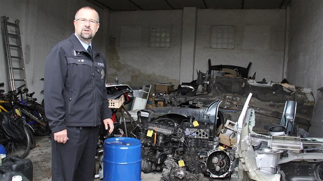 Policejn mluv Ji Matzner stoj ve skladu s rozebranmi auty.