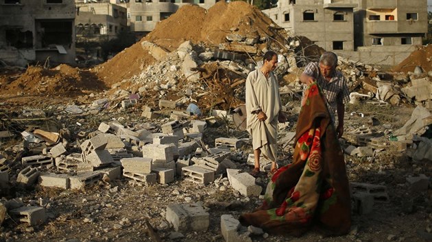 Palestinci stoj mezi troskami domu, kter byl znien izraelskm nletem na msto Gaza.