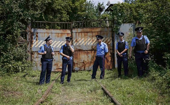 Ukrajintí policisté u bran továrny v Charkov, kam pevezli ostatky obtí z...