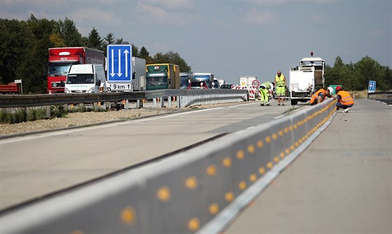 Dlníci pokládají stedové panely pro nové provizorní pruhy na modernizovaném...