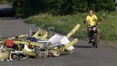 Místní lidé míjejí trosky letu MH17. (Ukrajina, 23. ervence 2014)