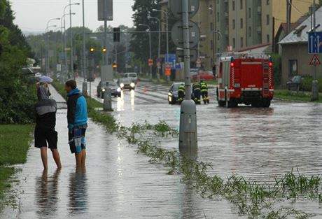 Hasii tlaí z vody zpt auto, které uvízlo na hlavním prtahu mstem.