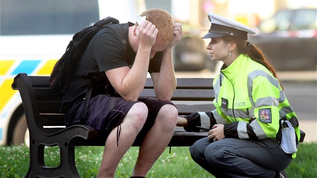 Policistka s jedním ze svědků tragické dopravní nehody na pražském Náměstí Kinských, při které zemřela mladá žena. (5. srpna 2014)