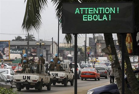 Konvoj OSN míjí ceduli varující ped ebolou v Abidanu v Pobeí slonoviny (14....