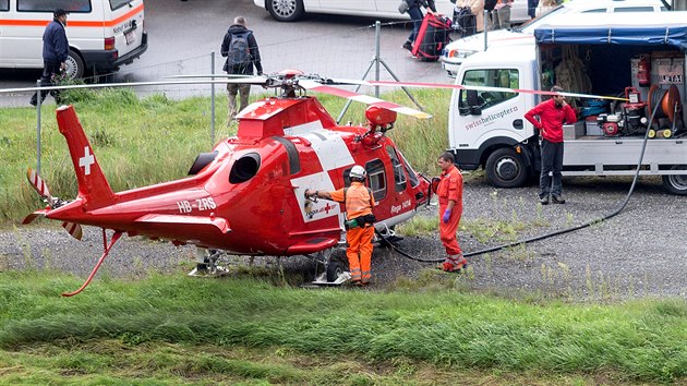 Pilot vcarskho zchranskho vrtulnku dopluje palivo ped zsahem u vykolejenho vlaku u obce Tiefencastel. (13. srpna 2014)