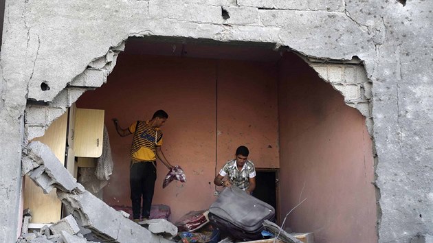 Palestinci v Rafhu si odn vci, kter zbyly z domu, kter byl podle svdk znien pi izraelskm nletu (20. srpna 2014).