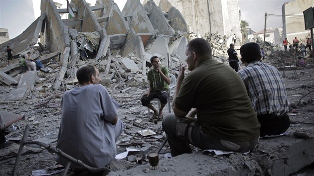Palestinci popj kvu vedle znien vkov budovy ve mst Gaza po rannm izraelskm deru (26. srpna 2014).