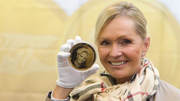 Helena Vondrkov pzuje v esk mincovn s medail se svm portrtem.