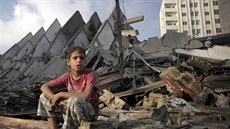 Palestinský chlapec sedí vedle zniené výkové budovy v Gaze (26. srpna 2014).