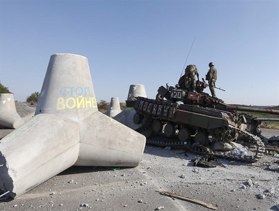 Ukrajintí vojáci prohlíejí poniený tank na kraji Mariupolu (6. záí 2014).