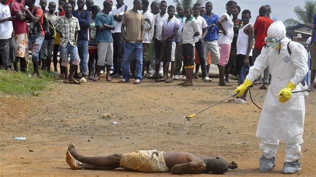 Zdravotnk v Monrovii dezinfikuje tlo lec na ulici. Nikdo nev, jestli nezemel na ebolu. (6. z 2014)
