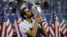 Chorvatský tenista Marin ili líbá trofej pro vítze US Open.