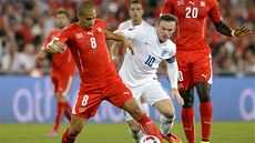 Kapitán anglické reprezentace Wayne Rooney atakuje výcarského fotbalistu