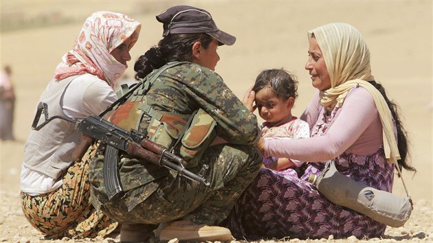 Kurdsk bojovnice utuje jezdsk eny, kter prchly ped Islmskm sttem (10. srpna 2014)