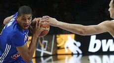 Francouzský basketbalista Nicolas Batum vniká do litevské obrany, brání Paulius...