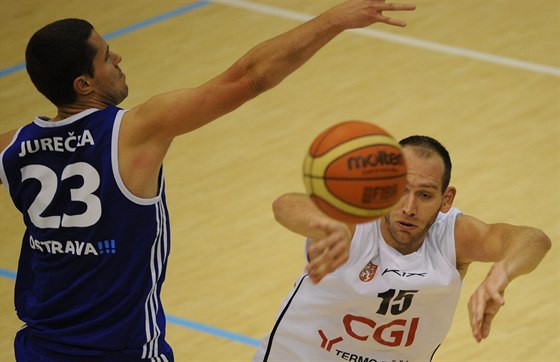 Dínský basketbalista Jakub Houka pihrává kolem ostravského Luka Jureky.