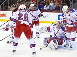 Travis Zajac z New Jersey sleduje zásah newyorského brankáe Cama Talbota.