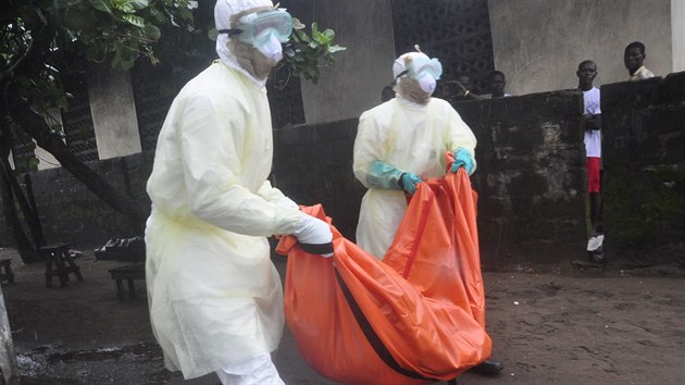 Zdravotnci v liberijsk Monrovii odnej tlo eny, kter zemela na ebolu  (8. jna 2014)
