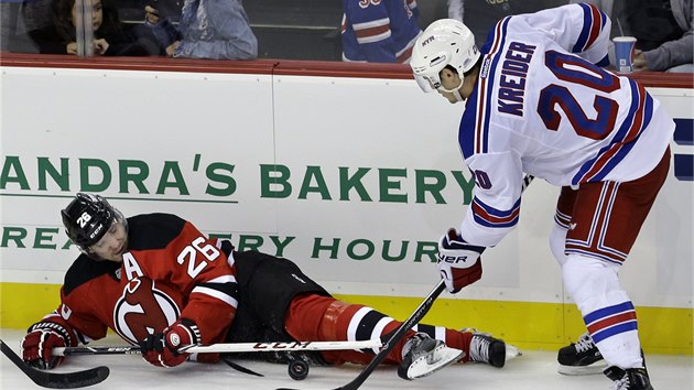 BOJOVN DERBY. Patrik Eli z New Jersey se sna udret puk, doluje ho Chris Kreider z New York Rangers.