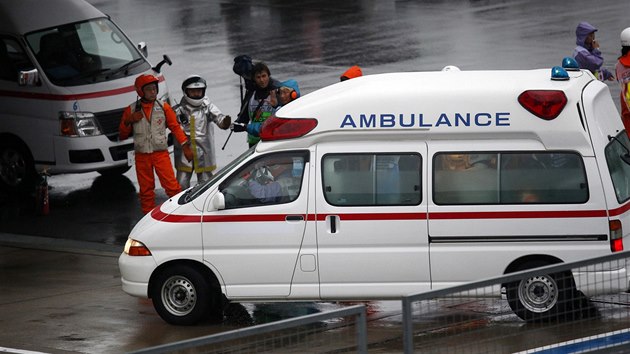 NA MST NEHODY. Sanitka se prodr do mst, kde havaroval Jules Bianchi ve Velk cen Japonska formule 1. 