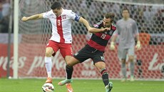 Polský fotbalista Robert Lewandowski (vlevo) v souboji o mí s Nmcem Mariem...