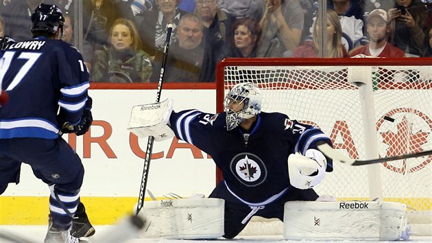 Brank Winnipegu Ondej Pavelec se natahuje marn. Na stelu Ondeje Palta z Tampy u nedoshne.