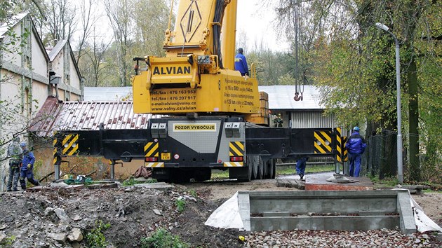 Instalace novho mostu pes eku Svatava ve stejnojmennm mstysu na Sokolovsku. Na behu je patrn betonov schod, kde bude uchycen jeden konec mostu.