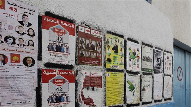 Lidé v Tunisu se dívají na pedvolební plakáty (22. íjna 2014).