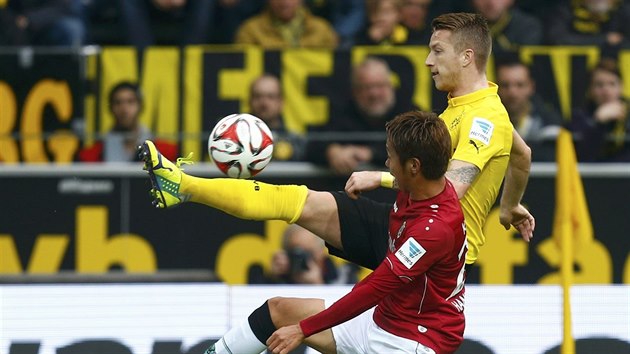 Marco Reus (ve lutm), zlonk Borussie Dortmund, bojuje o m s Hiroshim Kiyotakem z Hannoveru.