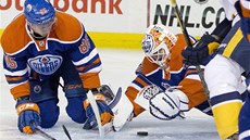 MÁM HO. Branká Edmontonu Ben Scrivens se vrhá po puku, jistí ho Martin