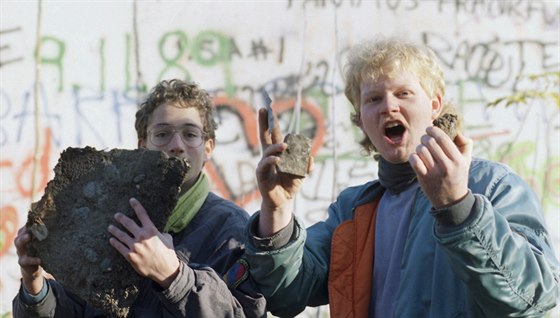 Dva mui hrd ukazují ásti Berlínské zdi, které nali u Braniborské brány po...