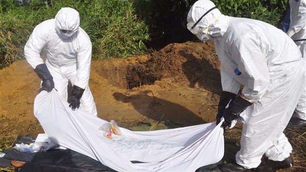 Zdravotnci na pedmst liberijsk Monrovii se chystaj pohbt pacienta, kter podlehl ebole (27. jna 2014).