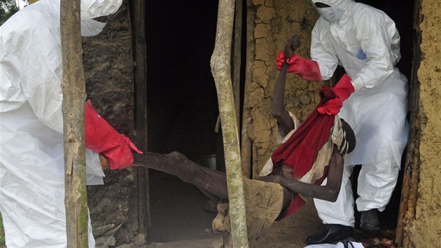 Zdravotnci vynej z domu na pedmst liberijsk Monrovie mue s podezenm na ebolu a chystaj se ho transportovat do izolace (31. jna 2014).