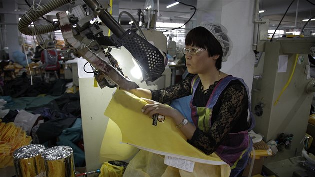 Pracovnice americk firmy ije v nsk provincii an-tung obleky, kter budou chrnit zdravotnky ped ebolou (30. jna 2014).