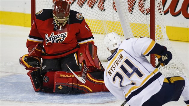 Calgarsk glman Jonas Hiller likviduje stelu  Erica Nystroma z Nashvillu.