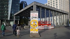 People walk past a segment of the former Berlin Wall at Potsdamer Platz square... People walk past a segment of the former Berlin Wall at Potsdamer Platz square...