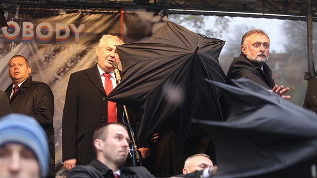Demonstranti vypskali na Albertov prezidenta Miloe Zemana. Na pdiu jej ped vhozenmi pedmty brnila ochranka a tajemnk Jaroslav Hlinovsk (17. listopadu 2014).