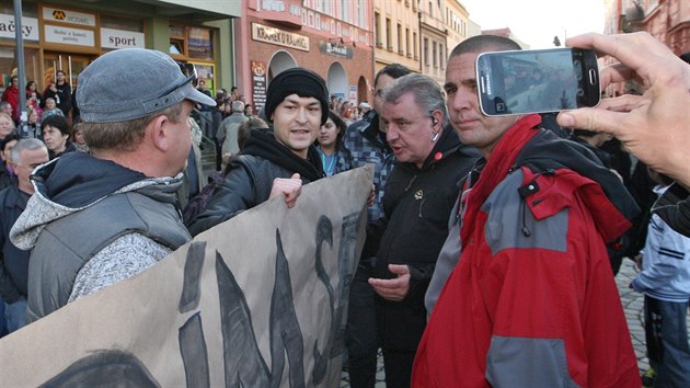 Dva mlad lidi s transparentem Stydm se za svho prezidenta brzy odvedli policist v civilu. (11. listopadu 2014)