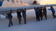 Pasažéři aerolinek UTair roztlačují letadlo na letišti v sibiřské Igarce. Pasažéři aerolinek UTair roztlačují letadlo na letišti v sibiřské Igarce.