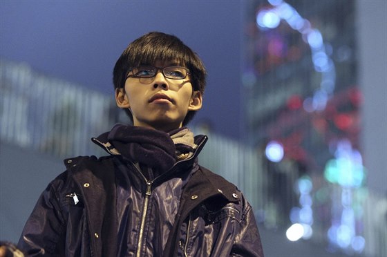 Joshua Wong stojí na pódiu v míst protest v Hongkongu.