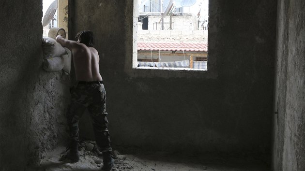 Povstalec dv pytle s pskem do oken na pedmst Aleppa (6. prosince 2014).